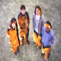 a group of people standing in front of a fire